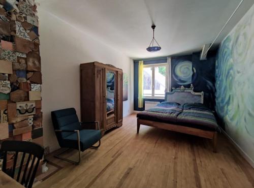 Een rustige en artistieke slaapkamer met houten meubels en een schilderachtig uitzicht, perfect voor rustzoekers in een bosrijke omgeving in de Lage Vogezen, Frankrijk.